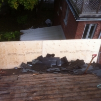 Erecting a barrier on a steep roof so old shingles do not fall onto property